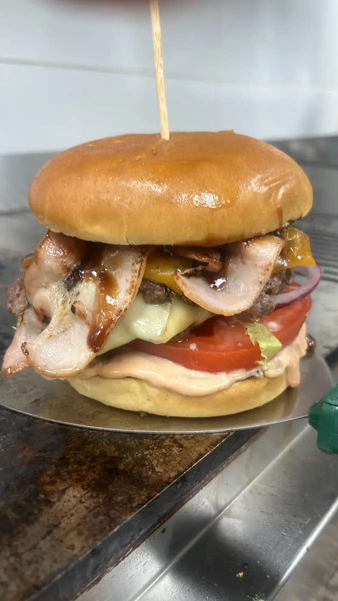 Burger con bacon a la plancha, queso, tomate y cebolla morada