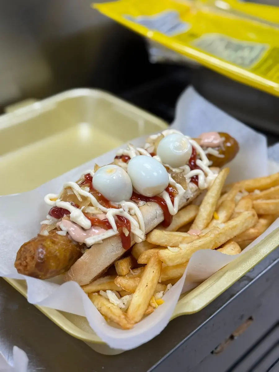 Perrito con huevos de codorniz, salsas y patatas fritas